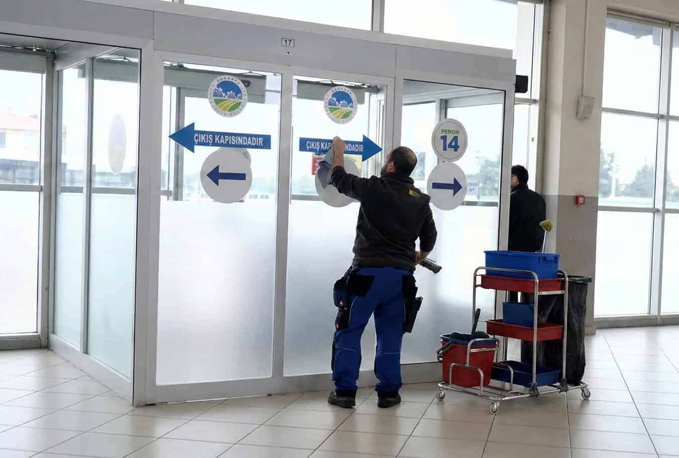 Güvenlik kapısından giriş ve çıkış yönlerini gösteren güvenlik görevlisi.